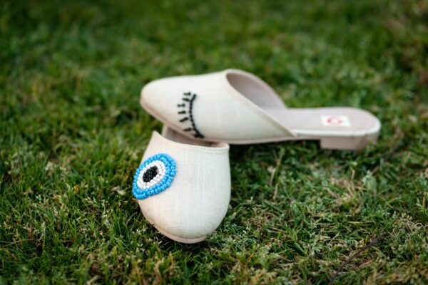 سليبر أوف وايت به تطريز لرسمة عين باللون اللبني-slipper