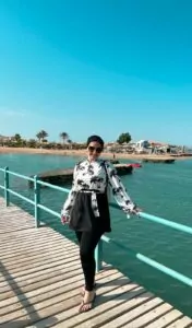 our client فتاة ترتدي مايوه اسود وابيض وعليه طبعه نخيل متعددة باللون الاسود